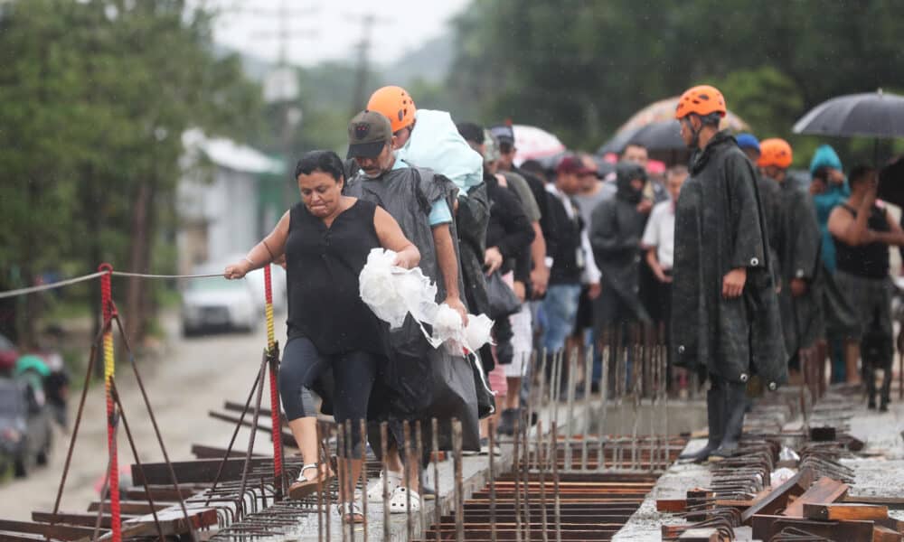 Personas evacúan debido a las crecidas de ríos y quebradas por el paso de la tormenta Sara, en el sector de la aldea Tikamaya, en la ciudad de San Pedro Sula (Honduras). EFE/ Gustavo Amador