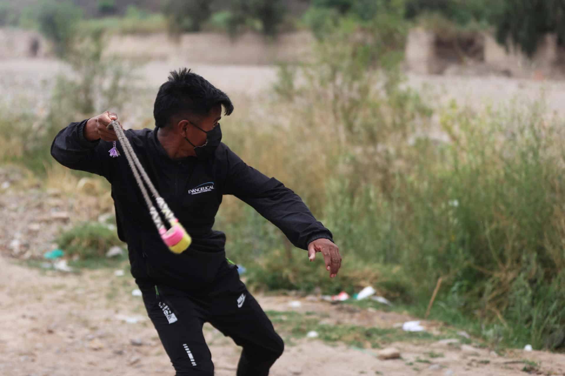 Un hombre lanza una piedra utilizando una onda o 'Waraka' durante un entrenamiento, este jueves en Parotani (Bolivia). EFE/ Luis Gandarillas