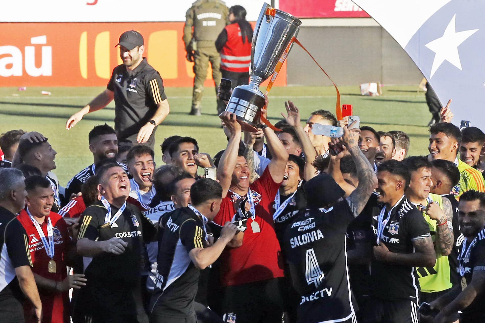 El entrenador argentino Jorge Almirón (c) levanta la copa que da a Colo Colo este domingo el título 34 en la liga chilena. EFE/ Luis Hidalgo