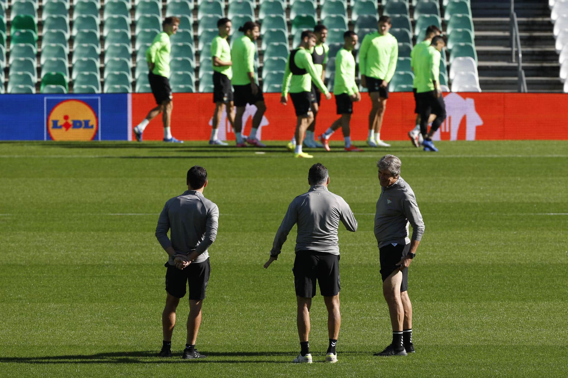 El entrenador del Real Betis, Manuel Pellegrini (d), observa durante la sesión de entrenamiento de su equipo este miércoles en el estadio Benito Villamarín, donde mañana juegan ante el NK Celje en el tercer partido de la liguilla de la Liga Conferencia. EFE/ Julio Muñoz