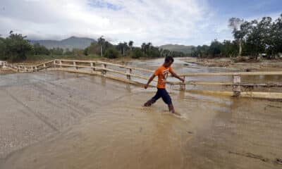 Fotografía de archivo del 29 de octubre de 2024 en donde un joven camina por una calle inundada en la región de San Antonio del Sur tras el paso de la tormenta tropical Óscar, en la provincia de Guantánamo, a más de 900 km de La Habana (Cuba). EFE/ Ernesto Mastrascusa