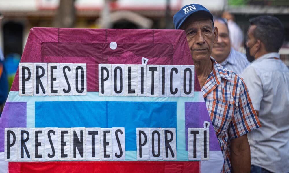 Fotografía de archivo del 8 de agosto de 2024 de un hombre que sostiene un cartel durante una gran vigilia nacional por la liberación de los que consideran presos políticos, convocada por la oposición en la plaza Los Palos Grandes de Caracas (Venezuela). EFE/ Henry Chirinos