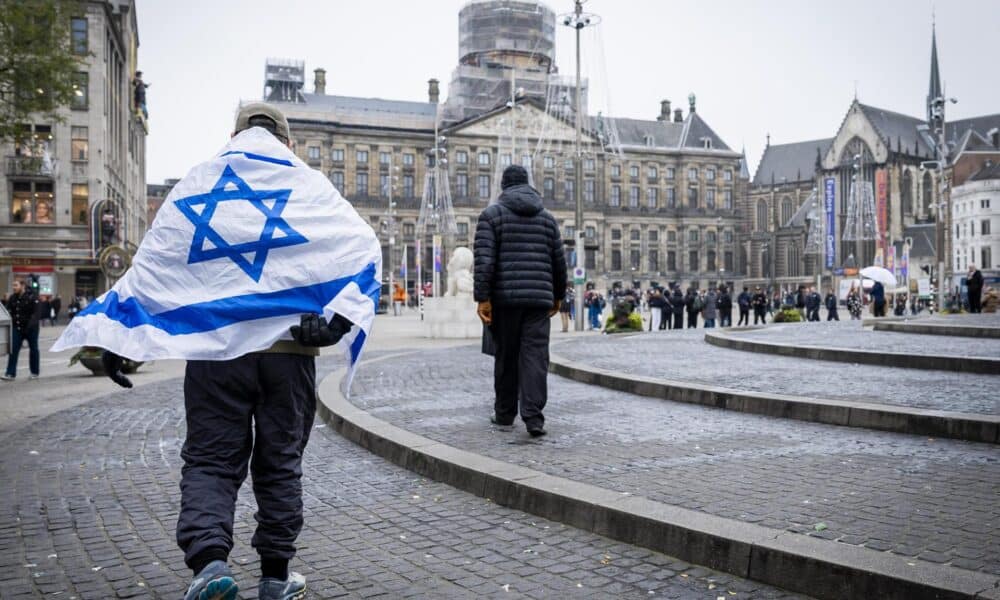 Un hombre que lleva una bandera israelí sobre sus hombros camina por la Plaza Dam en Ámsterdam, Países Bajos, el 8 de noviembre de 2024. EFE/EPA/Remko de Waal