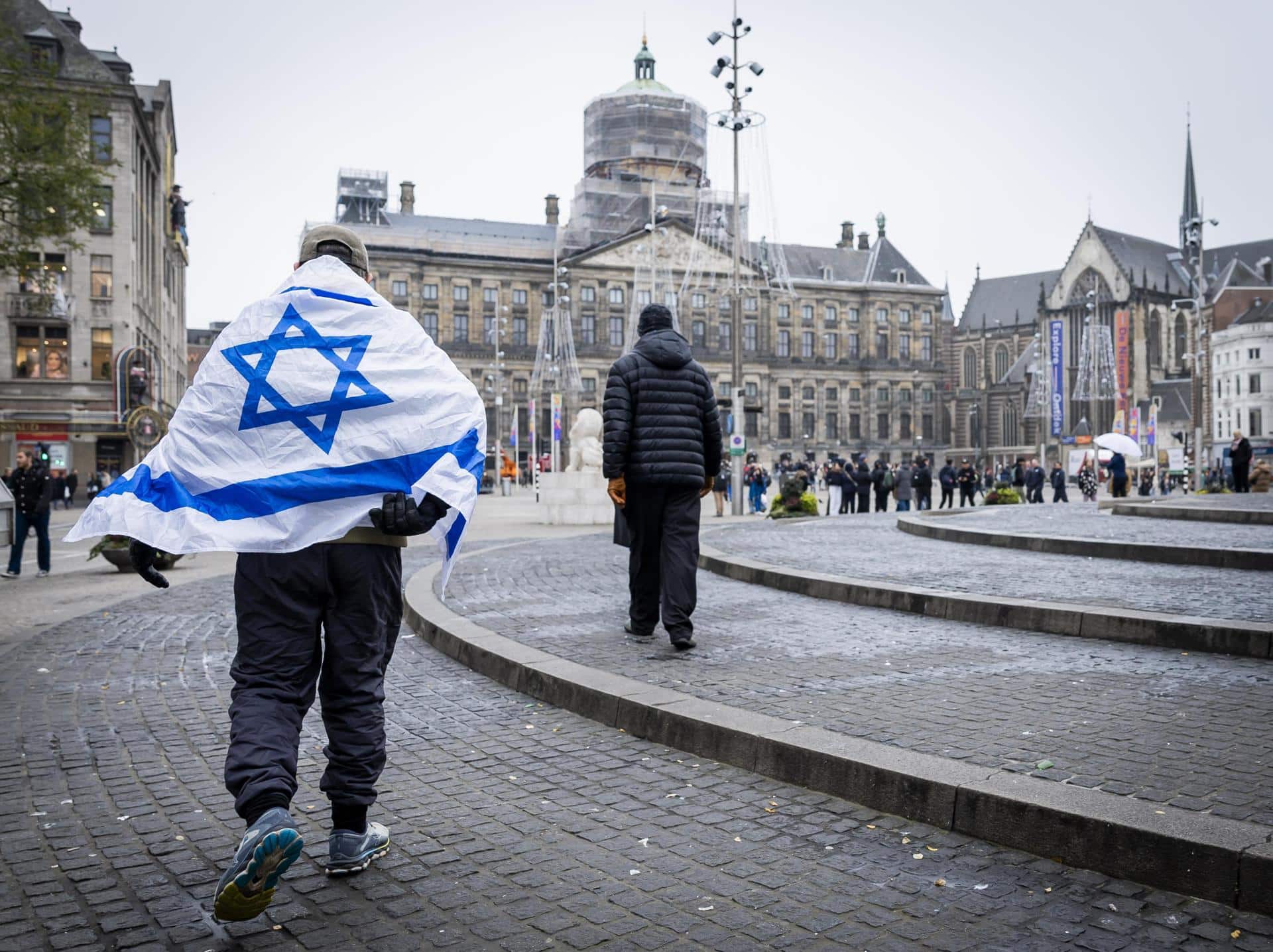 Un hombre que lleva una bandera israelí sobre sus hombros camina por la Plaza Dam en Ámsterdam, Países Bajos, el 8 de noviembre de 2024. EFE/EPA/Remko de Waal