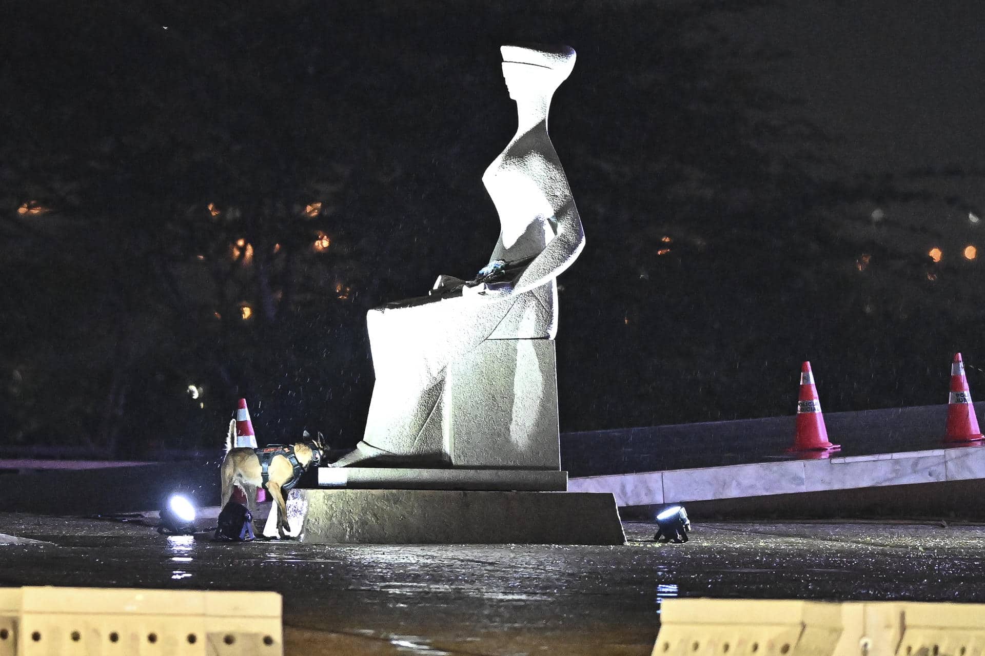 Un perro especializado en la detección de bombas rastrea los alrededores de la Estatua de la Justicia, lugar del suceso, en la Plaza de los Tres Poderes en Brasilia (Brasil), el 14 de noviembre de 2024. EFE/ Andre Borges