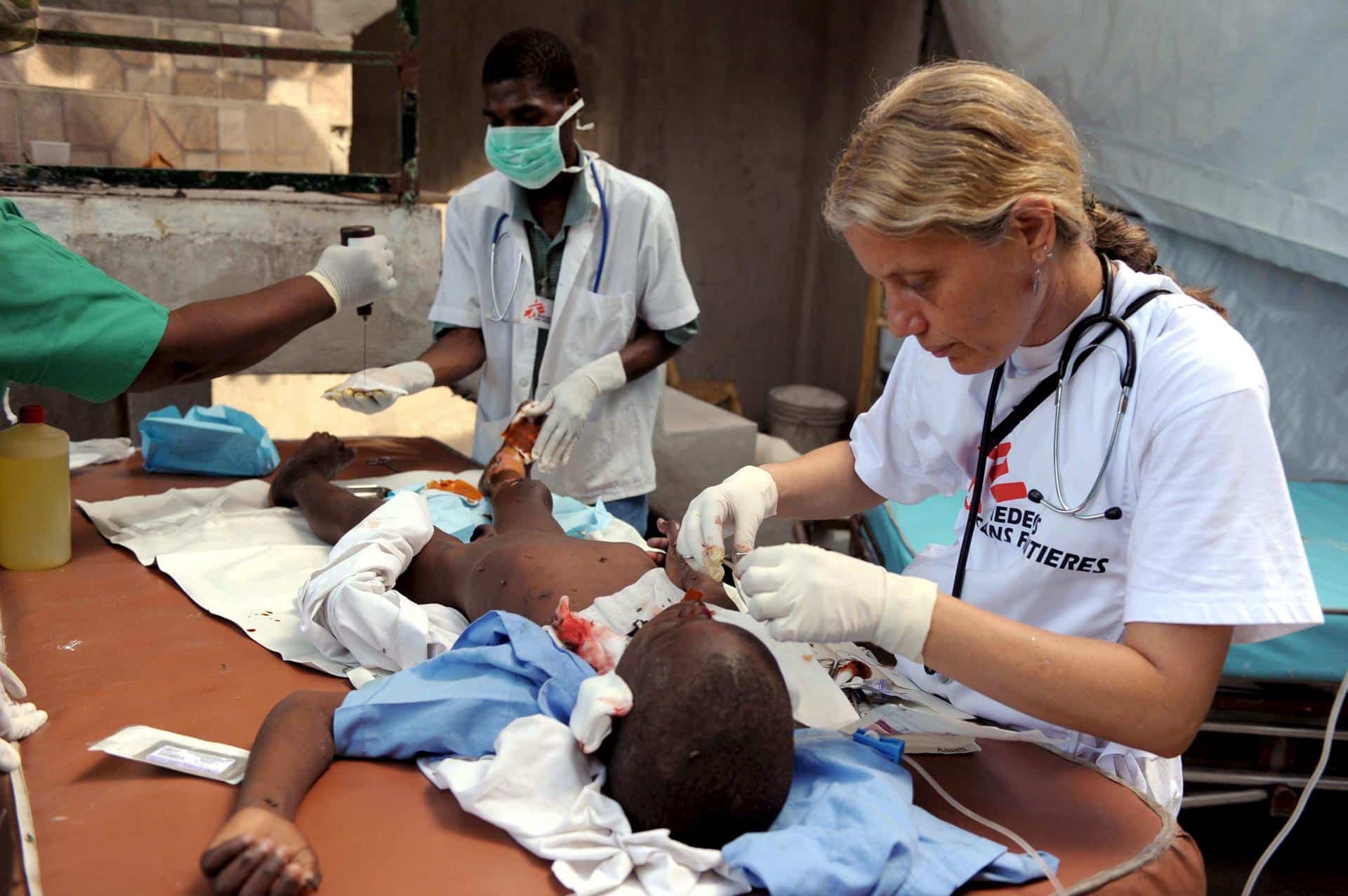 Foto de archivo donde se ve a voluntarios de Médicos Sin Fronteras atendiendo a un niño herido en un hospital de campaña en Puerto Príncipe, Haití. EFE/Federico Gambarini