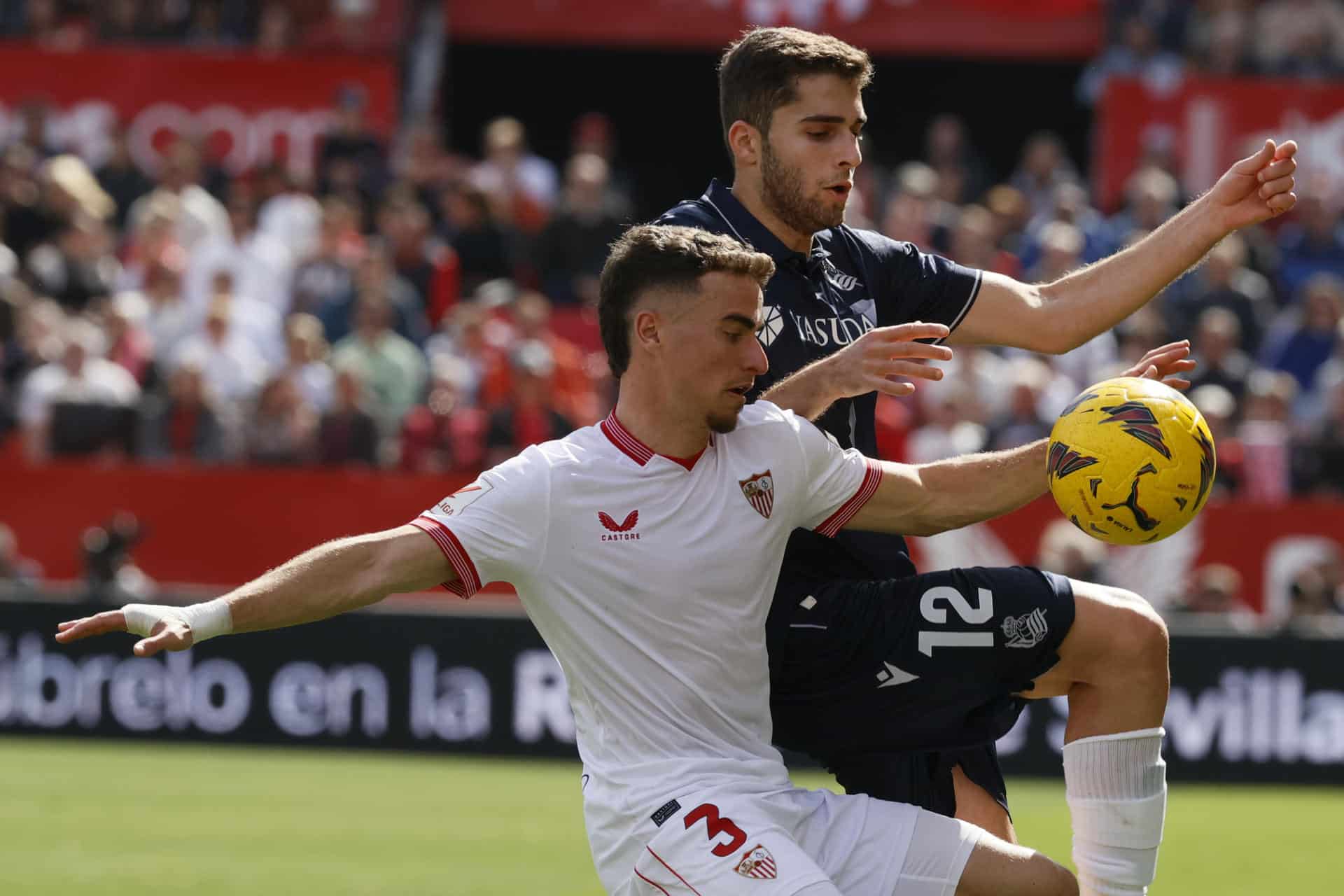 Fotografía de archivo del defensa del Sevilla Adrià Pedrosa y del centrocampista ruso de la Real Sociedad Arsen Zakharyan, durante un partido entre el Sevilla y la Real Sociedad. EFE/José Manuel Vidal