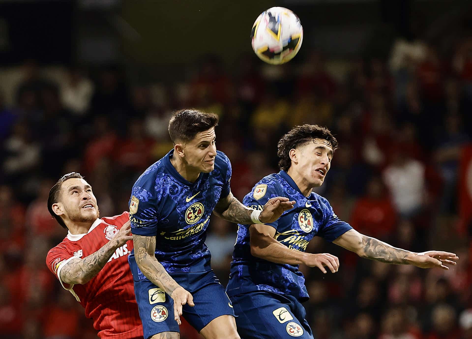 Jesús Angulo (i) de Toluca disputa el balón con los jugadores del América Paul Rodríguez (c) y Alejandro Zendejas (d) este sábado, en partido de la jornada 17 del torneo Apertura mexicano jugado en el estadio Nemesio Diez. EFE/ Alex Cruz