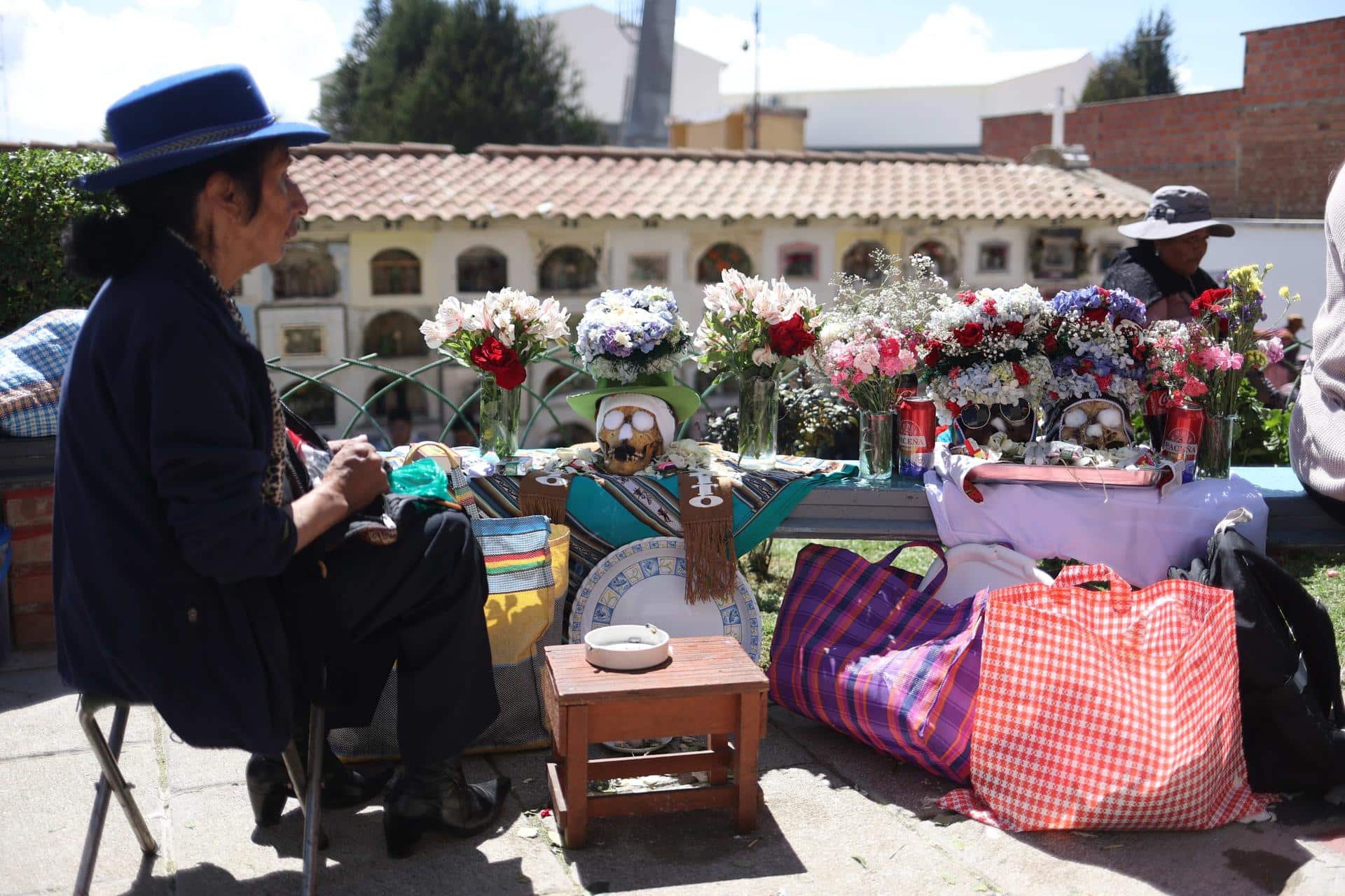 Mujeres participan durante la celebración de las "ñatitas" o cráneos humanos en el cementerio general este viernes en La Paz (Bolivia). EFE/Luis Gandarillas