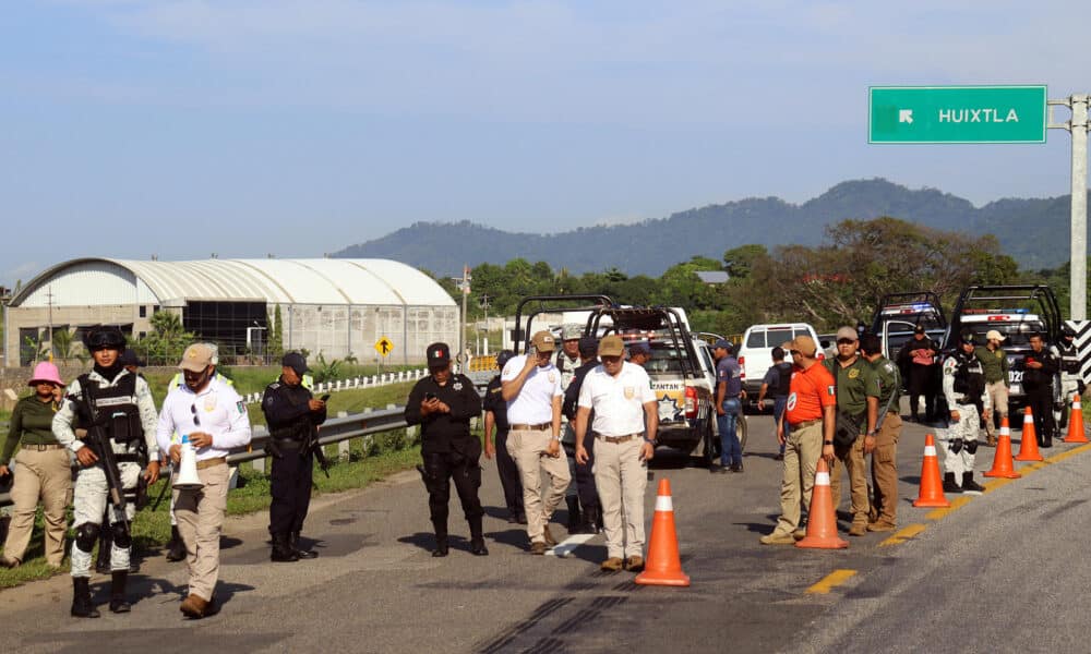 Personal del Instituto Nacional de Migración (INM) y de la Guardia Nacional (GN) bloquean una carretera ante el avance de una caravana de migrantes que caminan hacia la frontera con Estados Unidos este jueves, en el municipio de Huiixtla, en el estado de Chiapas (México). EFE/ Juan Manuel Blanco