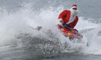 Un hombre disfrazado de Papá Noel hace figuras en una moto acuática antes de entregar regalos a niños con discapacidad este martes, en la playa de Copacabana en Río de Janeiro (Brasil). EFE/ Antonio Lacerda