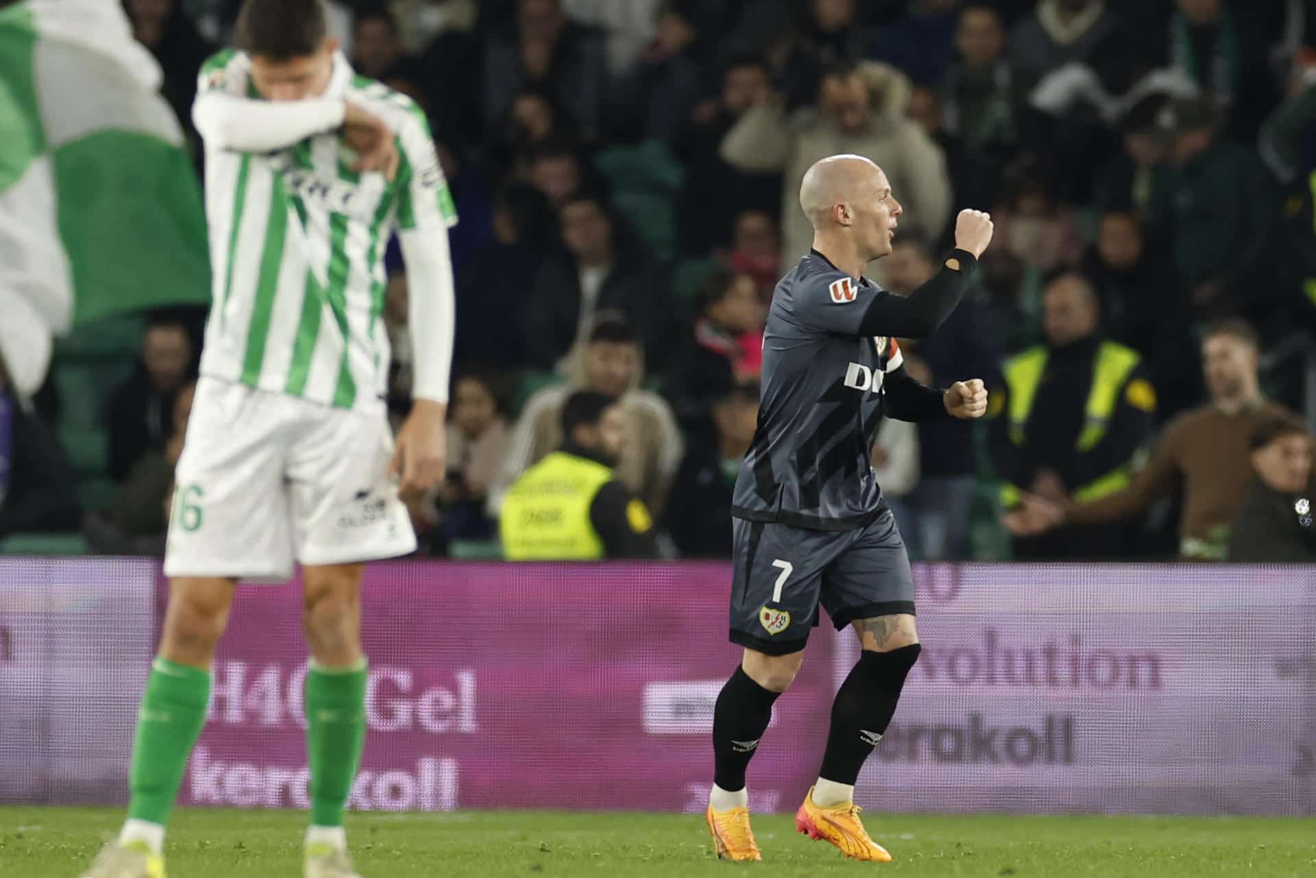 El centrocampista del Rayo Isi (d) celebra tras anotar el 1-1 del empate durante el partido de la jornada 18 de LaLiga EA Sports disputado este domingo entre el Real Betis y el Rayo Vallecano en el estadio Benito Villamarín de Sevilla. EFE/ Julio Muñoz