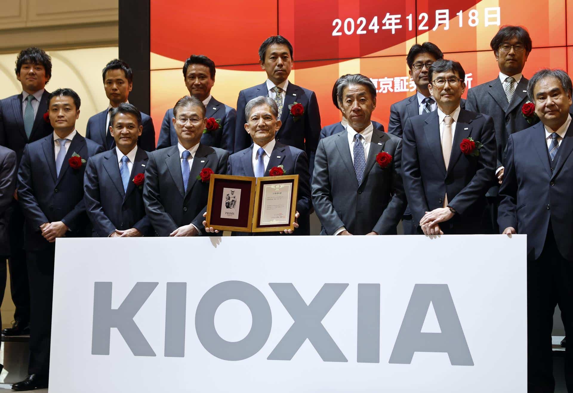 Nobuo Hayasaka (centro), presidente y director ejecutivo de Kioxia Holdings Corporation, posa con un certificado durante una ceremonia que marca el debut del fabricante japonés de chips en la Bolsa de Tokio, el 18 de diciembre de 2024. EFE/EPA/FRANCK ROBICHON