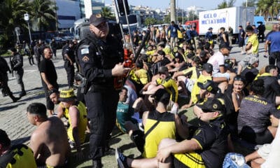 Fotografía de archivo, tomada el pasado 23 de octubre, en la que se registró a un grupo de aficionados del club uruguayo de fútbol Peñarol detenidos por actos vandálicos en una playa de Río de Janeiro (Brasil). Aún once de estos hinchas permanecen detenidos en Brasil. EFE/André Coelho