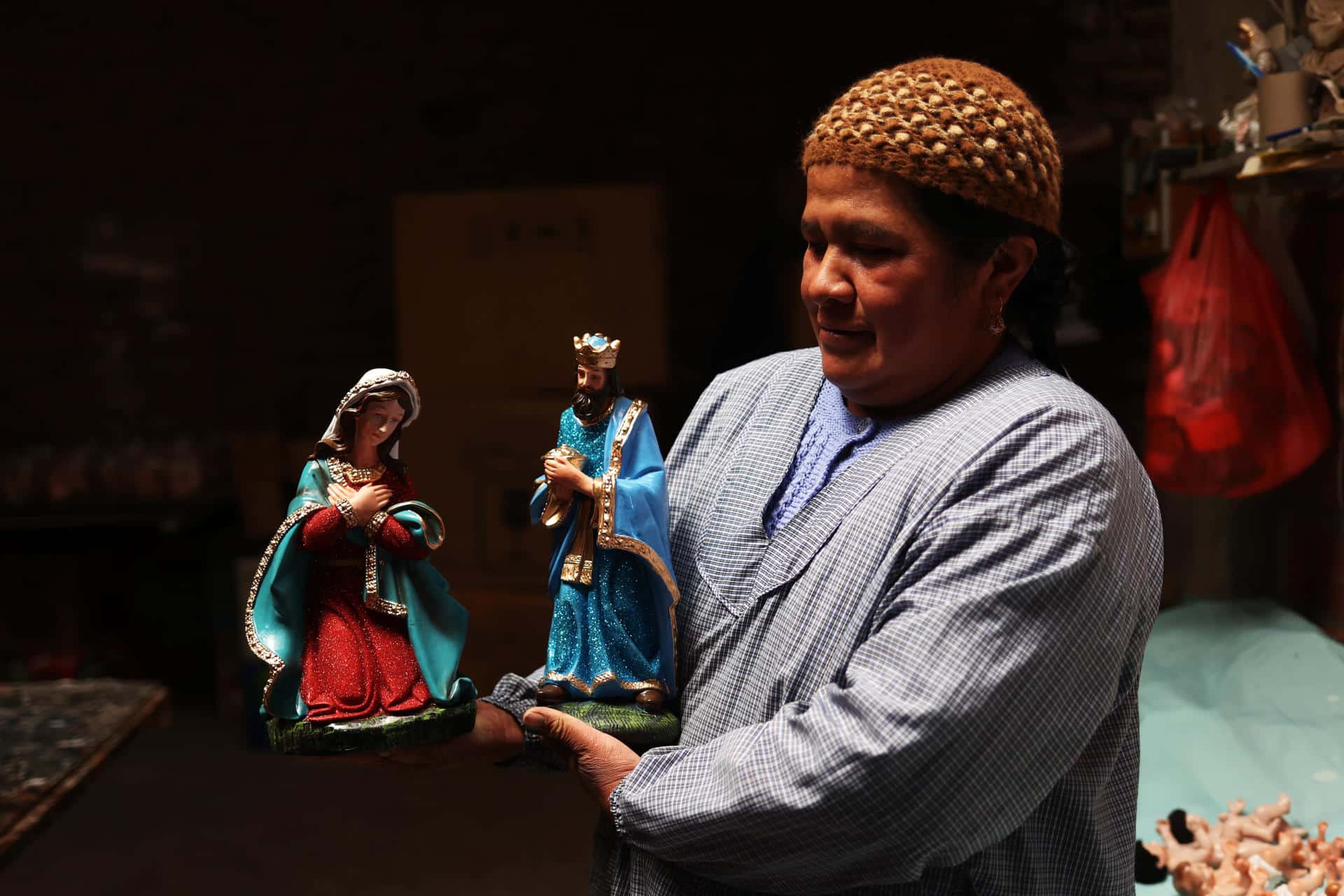 Fotografía del 10 de diciembre de 2024 de Olma Nina sosteniendo figuras en el taller 'Alaski' en El Alto (Bolivia). EFE/ Luis Gandarillas