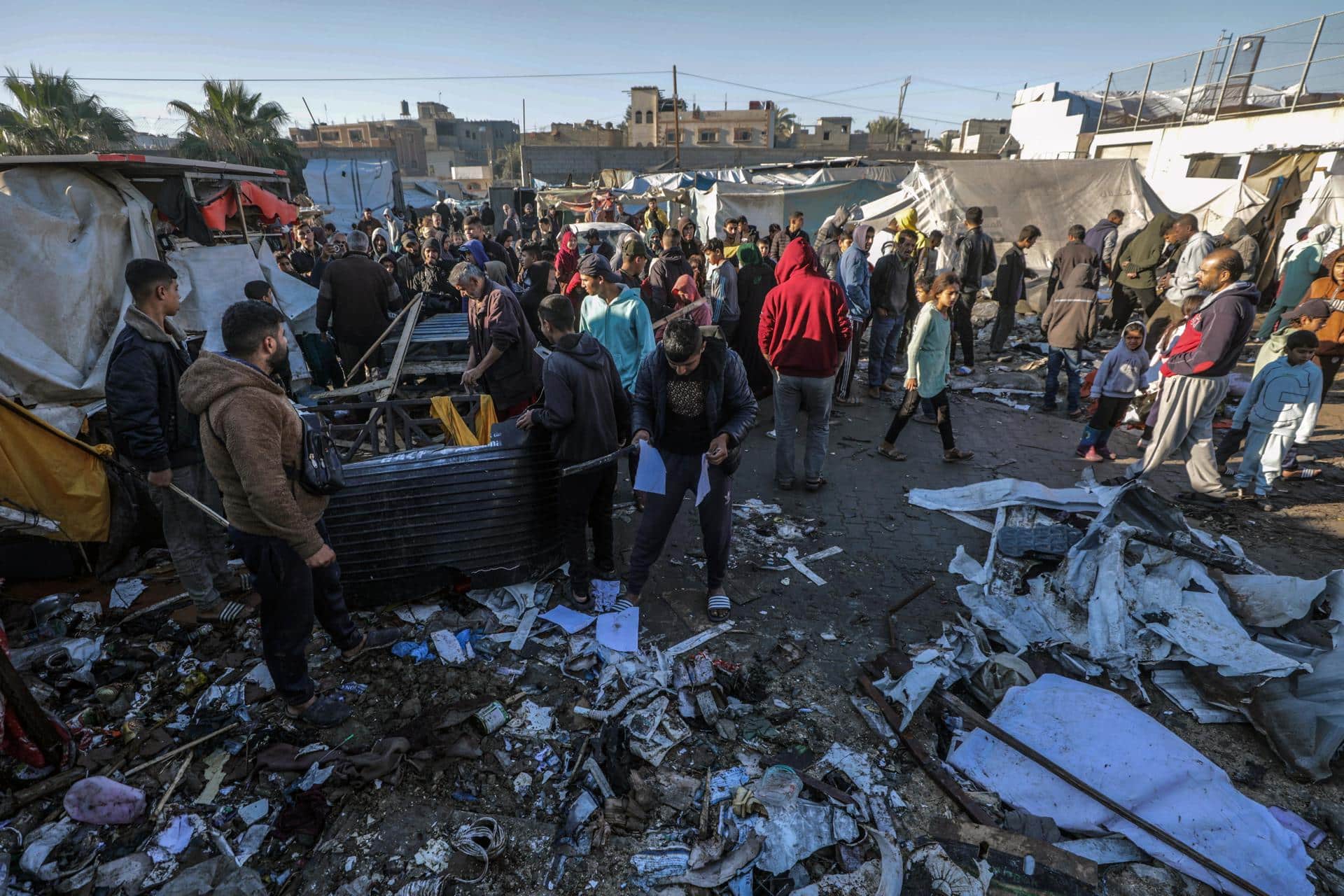 Palestinos desplazados inspeccionan las tiendas destruidas dentro del estadio Al Dura tras un ataque aéreo israelí en el oeste de la ciudad de Deir al-Balah, en el centro de la Franja de Gaza, 15 de diciembre de 2024. 
EFE/EPA/MOHAMMED SABER