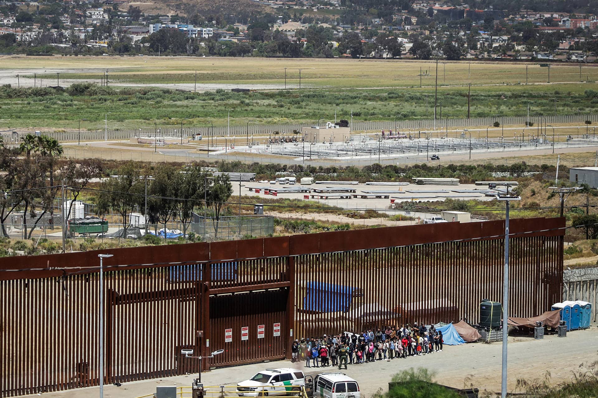 Imagen de archivo de migrantes que permanecen en la línea divisoria entre México y EEUU, en Tijuana (México). EFE/ Joebeth Terriquez