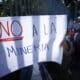 Una persona sostiene una pancarta durante una manifestación frente a la asamblea legislativa, el 23 de diciembre de 2024, en San Salvador (El Salvador). EFE/ Rodrigo Sura