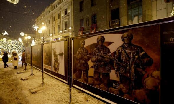 Varias personas pasan junto a la exposición 'Juntos hacia la victoria' de carteles militares creados por artistas y dedicados a los soldados rusos, en el centro de San Petersburgo, Rusia. EFE/EPA/ANATOLY MALTSEV