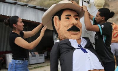 Dos jóvenes elaboran un monigote, conocido como 'Año Viejo', que representa al expresidente Manuel Zelaya, en la aldea de Germania, al sur de Tegucigalpa (Honduras). EFE/Gustavo Amador