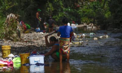 Fotografía de archivo en donde se ven dos mujeres que lavan ropa en un río contaminado con basura en la frontera entre Panamá y Colombia. EFE/ Bienvenido Velasco