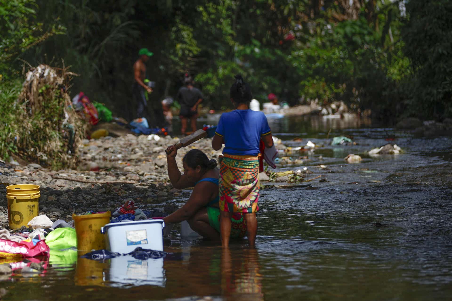 Fotografía de archivo en donde se ven dos mujeres que lavan ropa en un río contaminado con basura en la frontera entre Panamá y Colombia. EFE/ Bienvenido Velasco