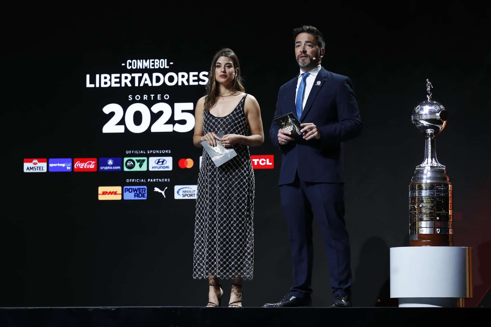 Los presentadores Marina Granziera (i) y Juan José Buscalia participan en el sorteo de la fase preliminar de la Copa Libertadores 2025. EFE/ Juan Pablo Pino