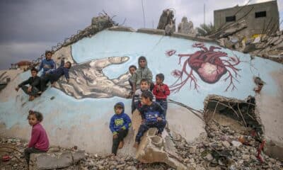 Foto de archivo de unos niños palestinos desplazados internamente juegan junto a un mural pintado sobre los escombros de una casa en Deir Al Balah, en la Franja de Gaza. EFE/ Mohammed Saber