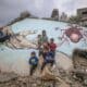 Foto de archivo de unos niños palestinos desplazados internamente juegan junto a un mural pintado sobre los escombros de una casa en Deir Al Balah, en la Franja de Gaza. EFE/ Mohammed Saber