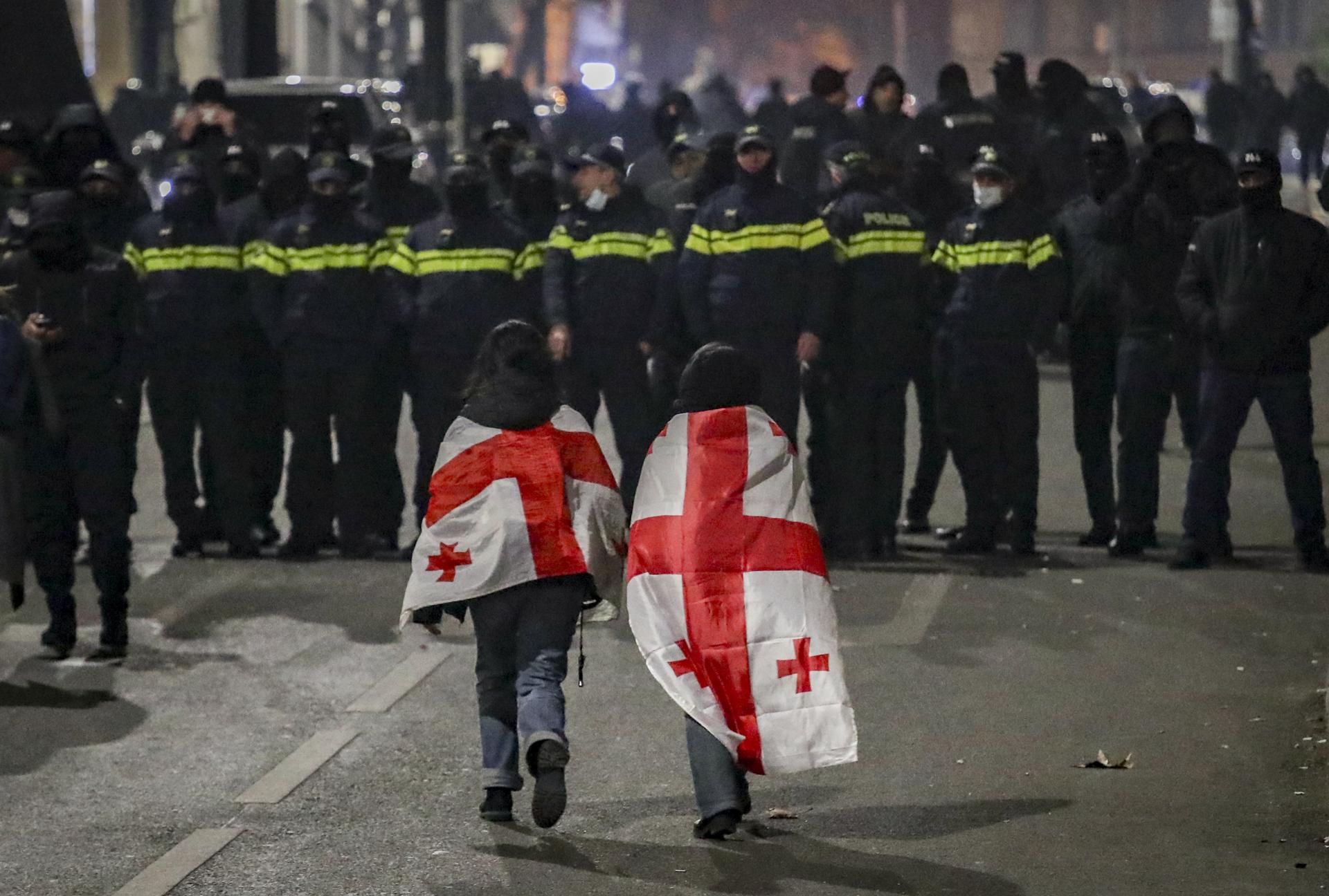 Fotografía de archivo de simpatizantes de la oposición georgiana que caminan frente a la policía durante una protesta frente al edificio del Parlamento en Tbilisi, Georgia, el 6 de diciembre de 2024. EFE/EPA/David Mdzinarishvili