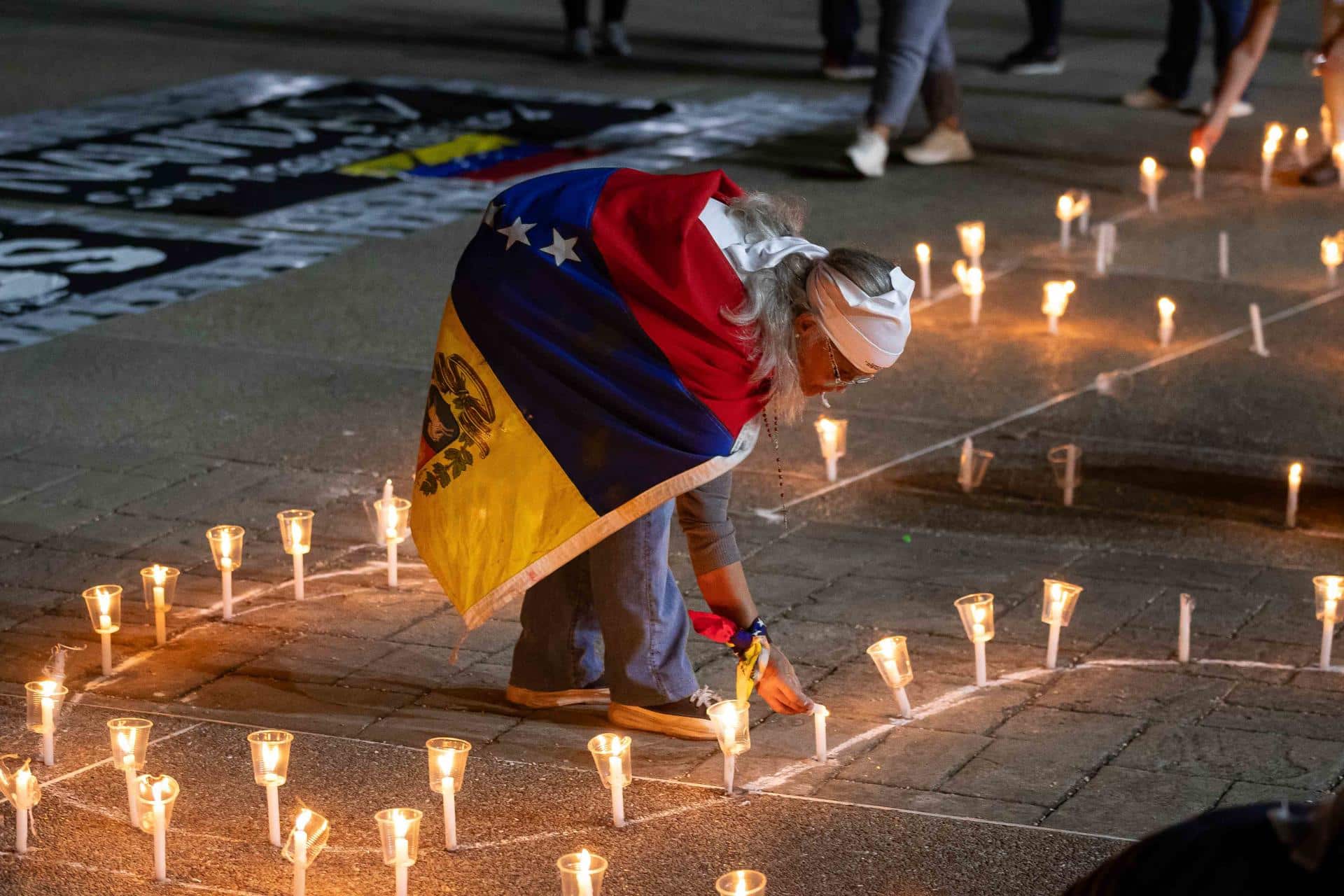 Una mujer enciende una vela durante una vigilia por los "presos políticos" en la Universidad Central de Venezuela (UCV) este martes, en Caracas (Venezuela). EFE/ Ronald Peña