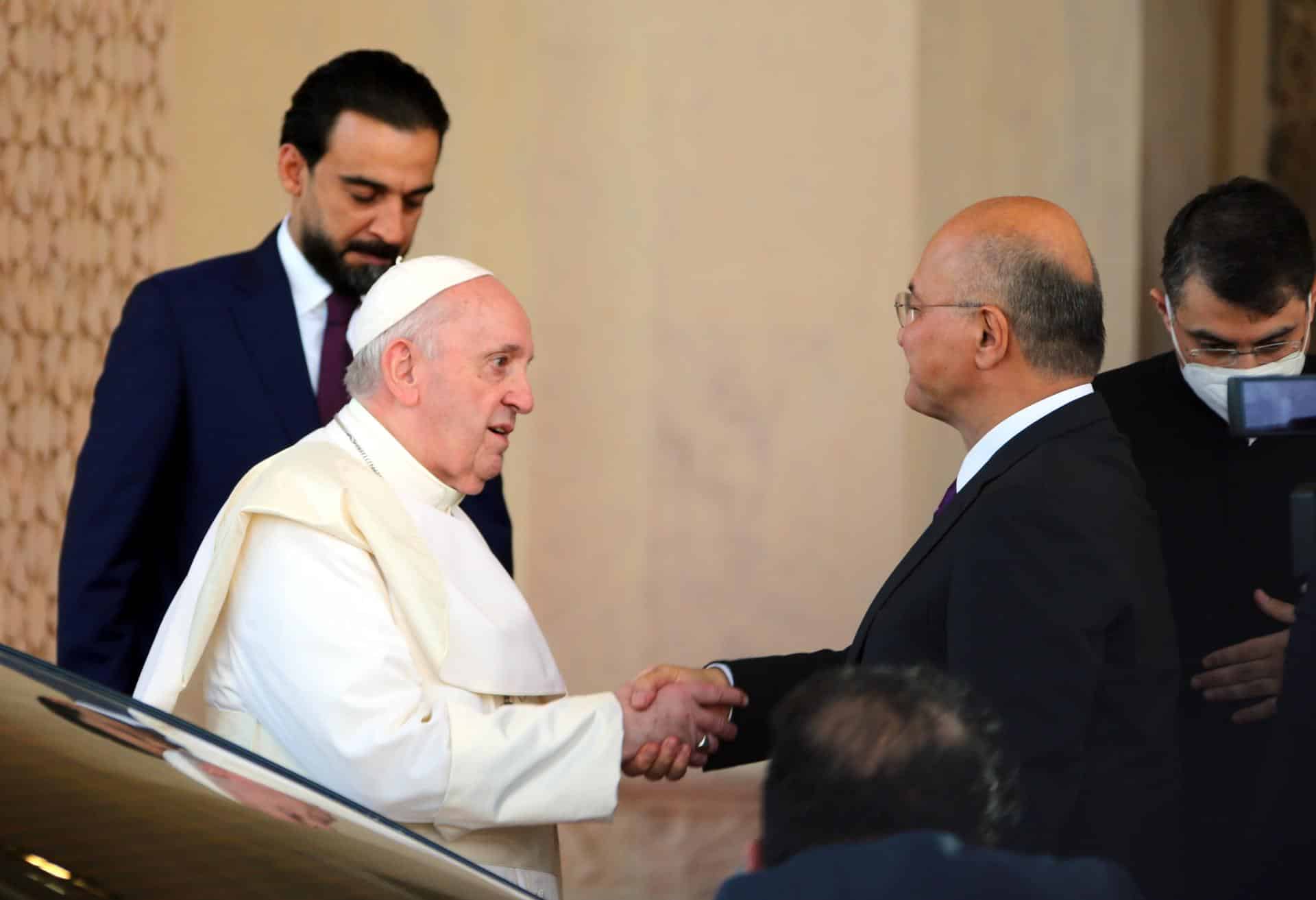 El papa Francisco (izq.) estrecha la mano del presidente iraquí, Barham Salih (der.) al salir del palacio presidencial tras una ceremonia oficial de bienvenida, en Bagdad, el 5 de marzo de 2021. EFE/EPA/AHMED JALIL