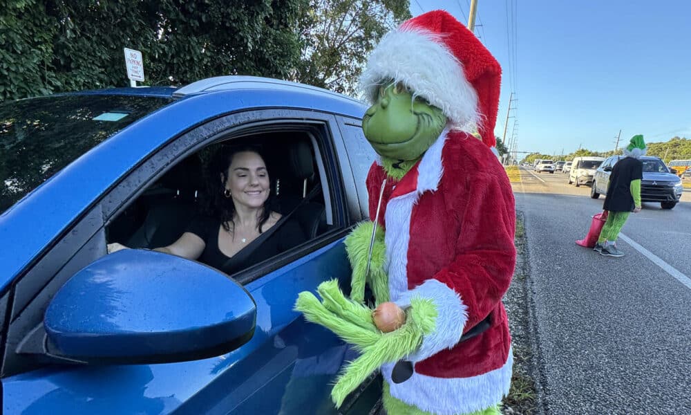 Fotografía cedida por la Oficina de Noticias de los Cayos de Florida donde aparece el coronel Lou Caputo, de la Oficina del Alguacil del Condado de Monroe, disfrazado de 'Grinch', el malvado duende verde navideño, ofreciendo una cebolla a una conductora que iba ligeramente con exceso de velocidad en una zona escolar este jueves en Cayo Largo, Florida (EE.UU.). EFE/Andy Newman/Oficina de Noticias de los Cayos de Florida /SOLO USO EDITORIAL /NO VENTAS /SOLO DISPONIBLE PARA ILUSTRAR LA NOTICIA QUE ACOMPAÑA /CRÉDITO OBLIGATORIO