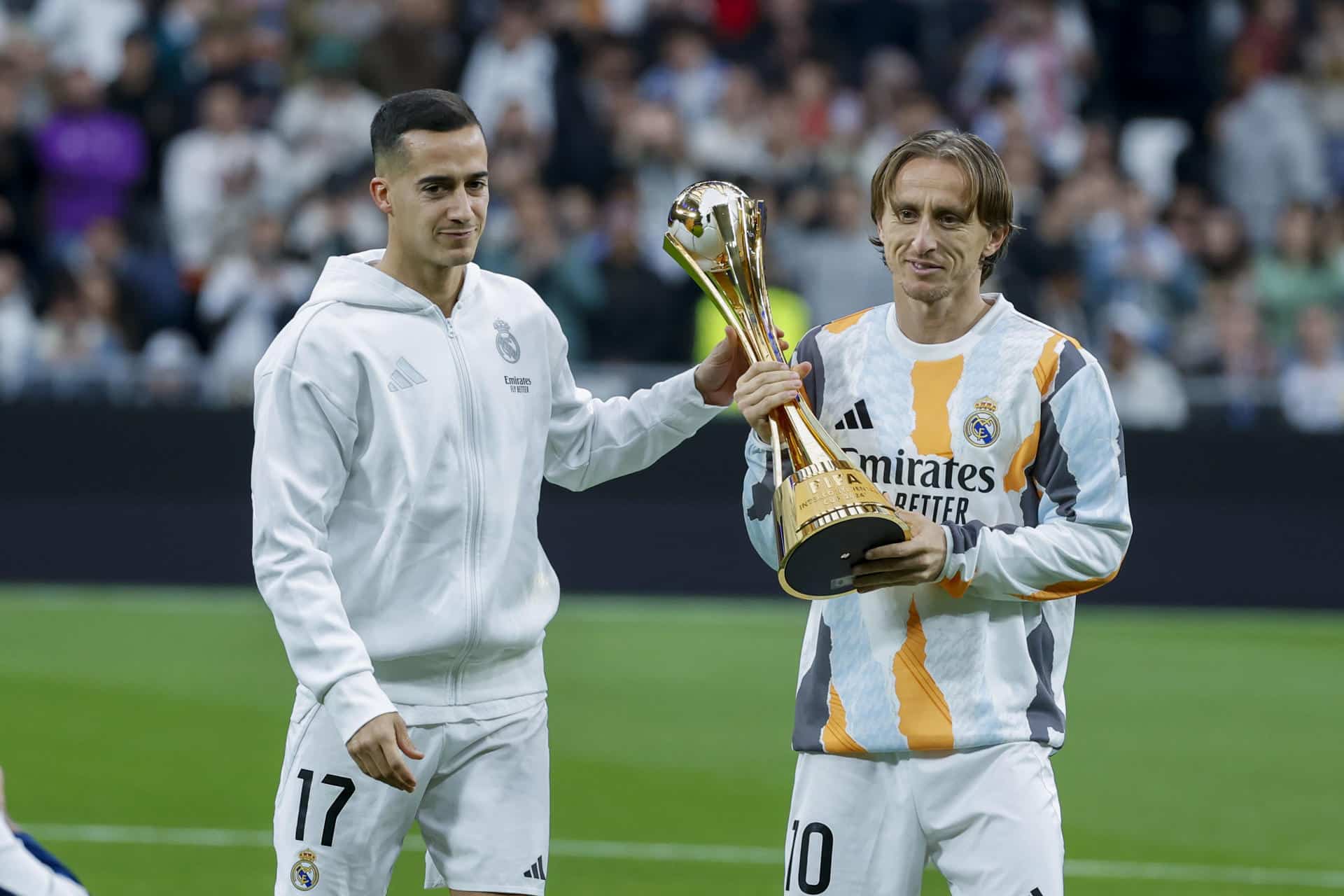 Los jugadores del Real Madrid Luka Modric (d) y Lucas Vázquez muestran al público el Trofeo de la Copa Intercontinental, en los momentos previos al partido de LaLiga entre el Real Madrid y el Sevilla, este domingo en el estadio Santiago Bernabéu. EFE/ JuanJo Martín