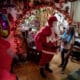 Un hombre vestido como Papá Noel saluda a una mujer en una casa este sábado, en Caracas (Venezuela). EFE/ Miguel Gutiérrez