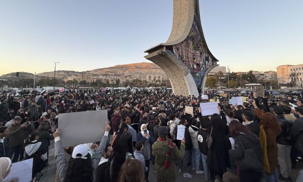 Centenares de personas se concentraron este jueves ante el monumento de la Espada Damascena, en la céntrica plaza de los Omeyas, en Damasco, portando pancartas y cantando lemas en defensa de una sociedad civil fuerte y diversa en un país laico que respete todas las sensibilidades religiosas. Ese es el mensaje compartido que han lanzado los manifestantes al nuevo Gobierno interino de Siria, que se estableció tras el derrocamiento del régimen del depuesto presidente Bachar al Asad, que se culminó el pasado 8 de diciembre con la caída de la capital en manos de la coalición islamista liderada por el Organismo de Liberación del Levante (Hayat Tahrir al Sham, o HTS en árabe). EFE/ Yahya Nemah