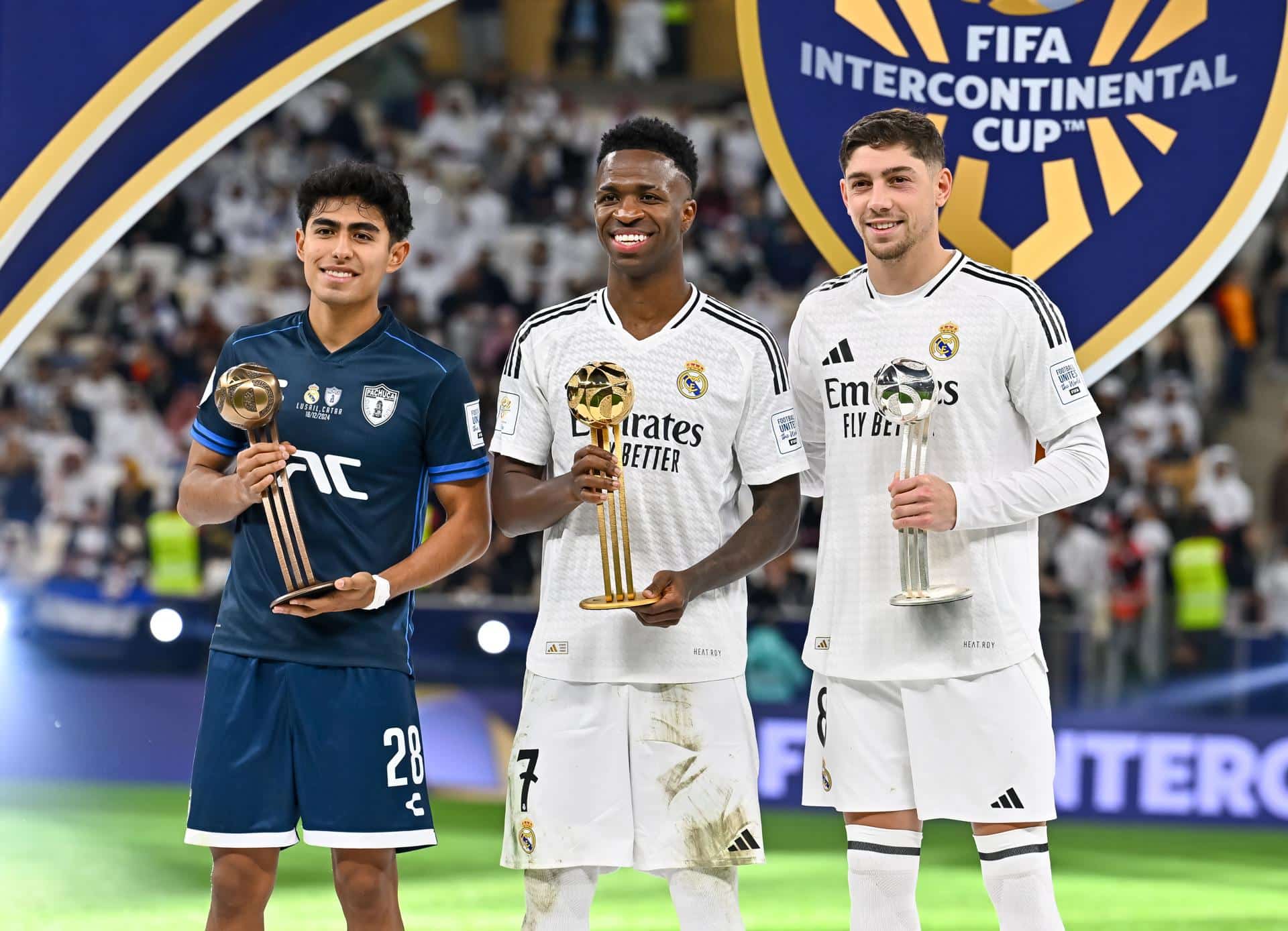 El jugador del Real Madrid Vinicius Junior (c), del Real Madrid, Elias Montiel (I), del CF Pachuca, y Federico Valverde (d), del Real Madri, posan con sus trofeos tras la final dela Copa Intercontinental que han jugado Real Madrid CF y CF Pachuca en Lusail, Catar. EFE/EPA/NOUSHAD THEKKAYIL