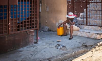 Fotografía de archivo en donde se ve a una mujer frente a una vivienda de una calle de Poste Marchand, en Puerto Príncipe (Haití). EFE/ Johnson Sabin