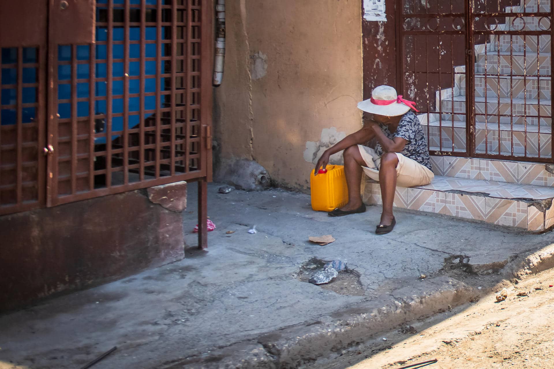 Fotografía de archivo en donde se ve a una mujer frente a una vivienda de una calle de Poste Marchand, en Puerto Príncipe (Haití). EFE/ Johnson Sabin