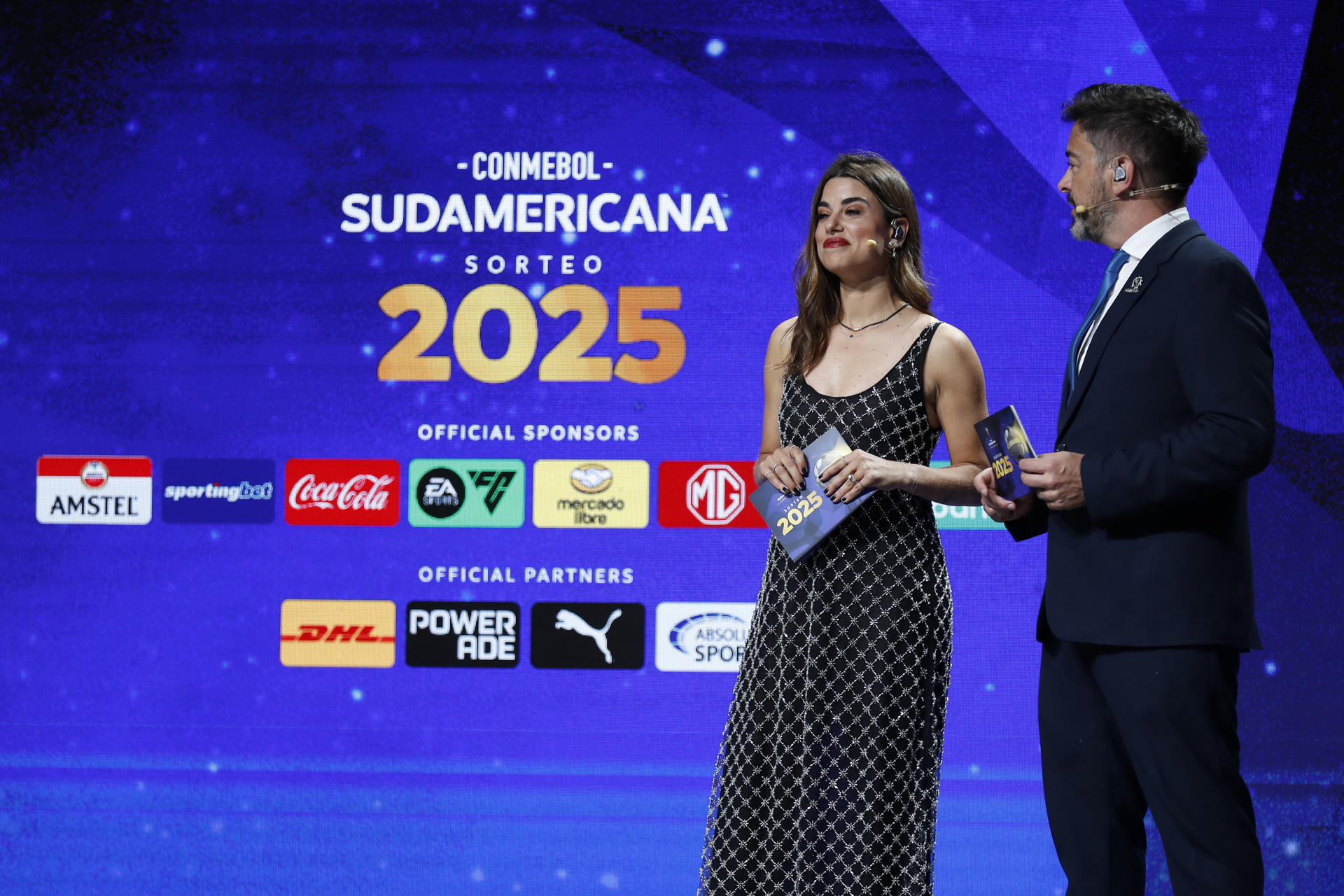 Los presentadores Marina Granziera (i) y Juan José Buscalia participan en el sorteo de la primera fase de la Copa Sudamericana 2025. EFE/ Juan Pablo Pino