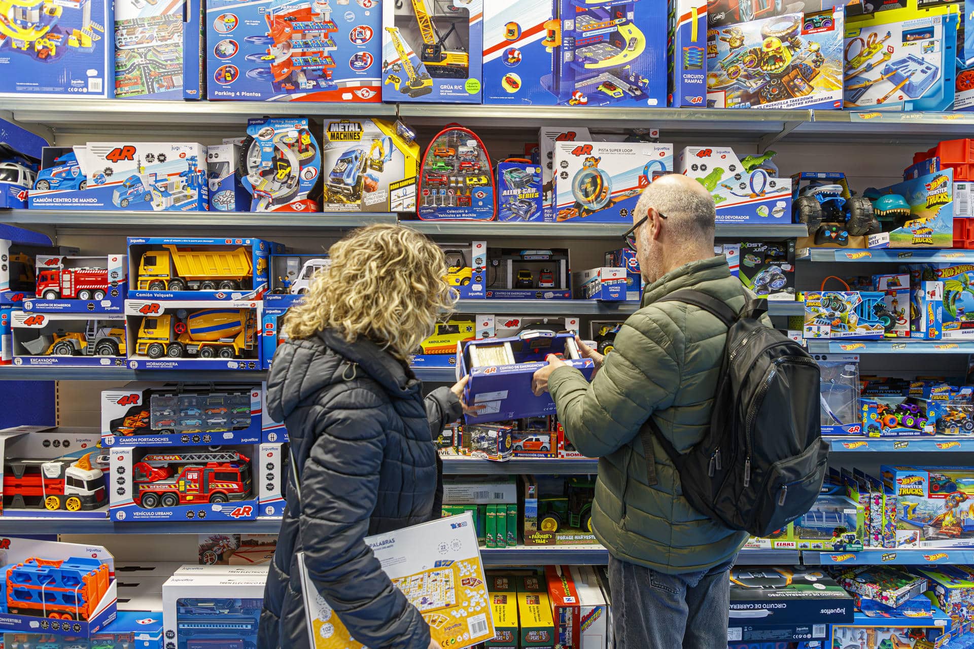 Dos adultos miran juguetes en un establecimiento de Zaragoza (España) unos días antes de la pasada Navidad. EFE/ Javier Belver