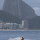 Un hombre disfrazado de Papá Noel hace figuras en una moto acuática antes de entregar regalos a niños con discapacidad, en la playa de Copacabana en Río de Janeiro (Brasil). EFE/Antonio Lacerda