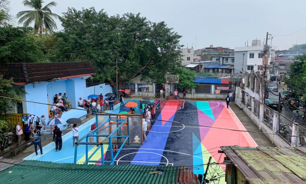 MANILA (FILIPINAS), 21/12/2024.- La cancha de baloncesto encastrada entre edificios humildes del barrio de Tejeros, en Manila, sirve como un centro vital para sus vecinos desde hace varias generaciones, y desde este sábado su suelo reluce con los colores del colectivo artístico español Boa Mistura. EFE/ David Asta Alares