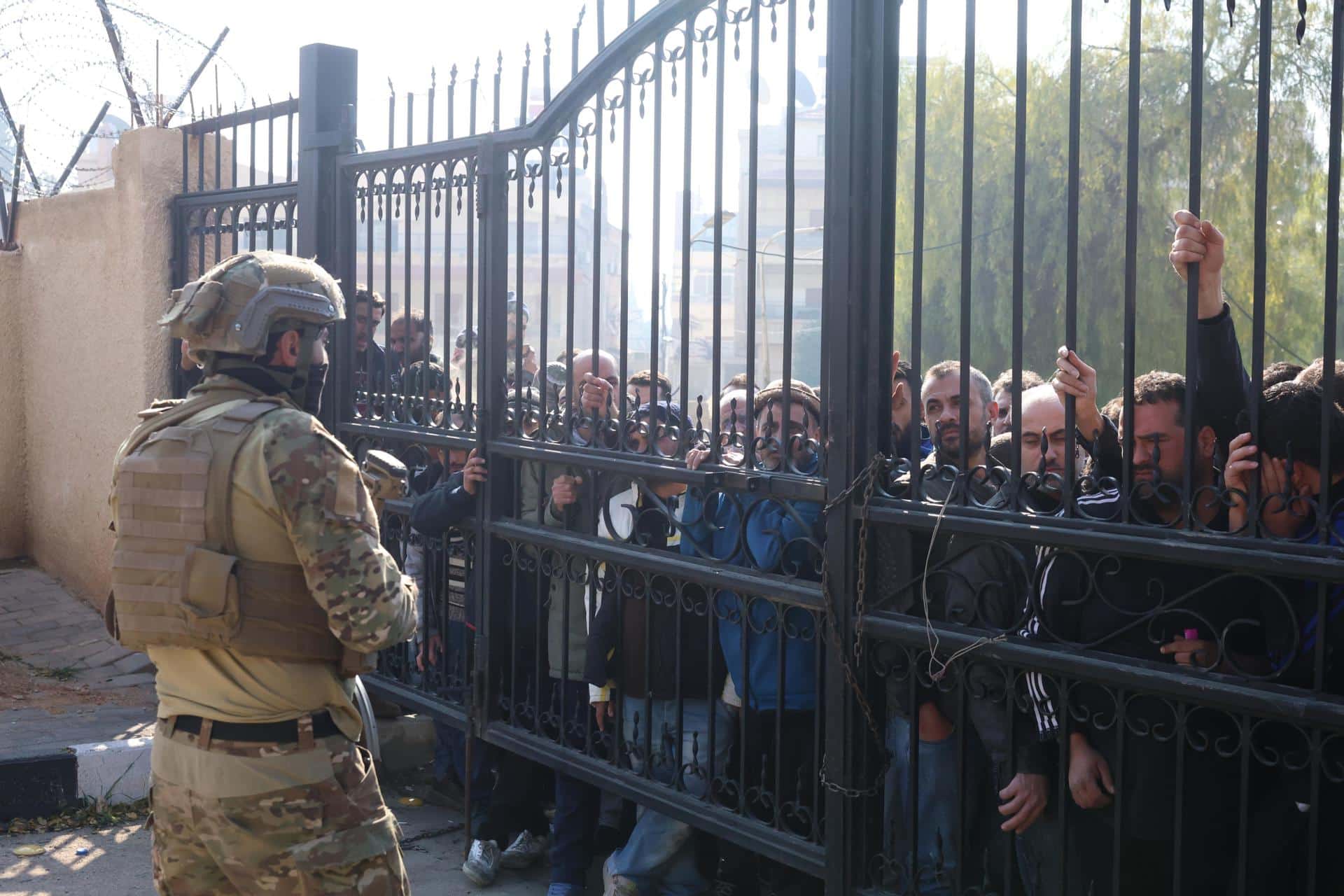 Un combatiente rebelde asegura el área mientras la gente espera para registrarse en una sucursal del centro para el proceso de registro y reconciliación en el distrito de Mezzeh, Damasco, Siria, el 21 de diciembre de 2024. El Departamento de Operaciones Militares abrió el primer centro para el proceso de registro y reconciliación de ex miembros del régimen sirio en el barrio de Mezzeh en Damasco.EFE/EPA/Mohammed Al Rifai