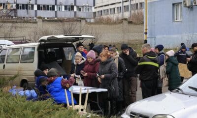 Jarkov (Ucrania), 25/12/2024.- Un grupo de personas hacen cola para recibir ayuda junto a un edificio de viviendas dañado por un ataque con un misil ruso en la ciudad ucraniana de Jarkov. EFE/EPA/SERGEY KOZLOV