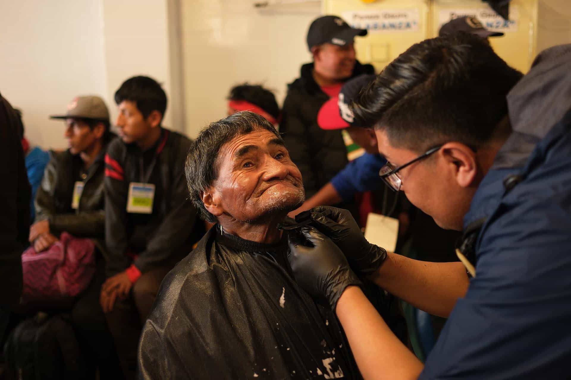 Un hombre recibe un corte de pelo y una afeitada durante una jornada de ayuda a personas en condición de calle, este viernes en La Paz (Bolivia). Cientos de personas en situación de calle participaron en la campaña del 'Buen Samaritano', organizada por una iglesia evangélica con la finalidad de brindar a este sector de la población aseo, alimentación, atención médica y apoyo espiritual durante las festividades de fin de año. EFE/ Luis Gandarillas