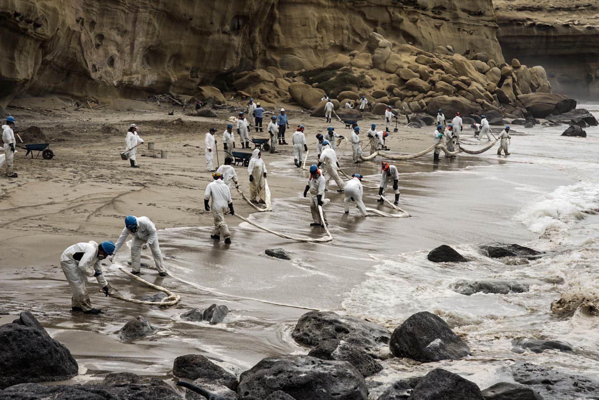 Integrantes de Petroperú limpian un derrame de petroleo en la playa La Capullana, distrito de Lobitos, en la provincia de Talara, en el norte de Perú. EFE/Malú Ramahí