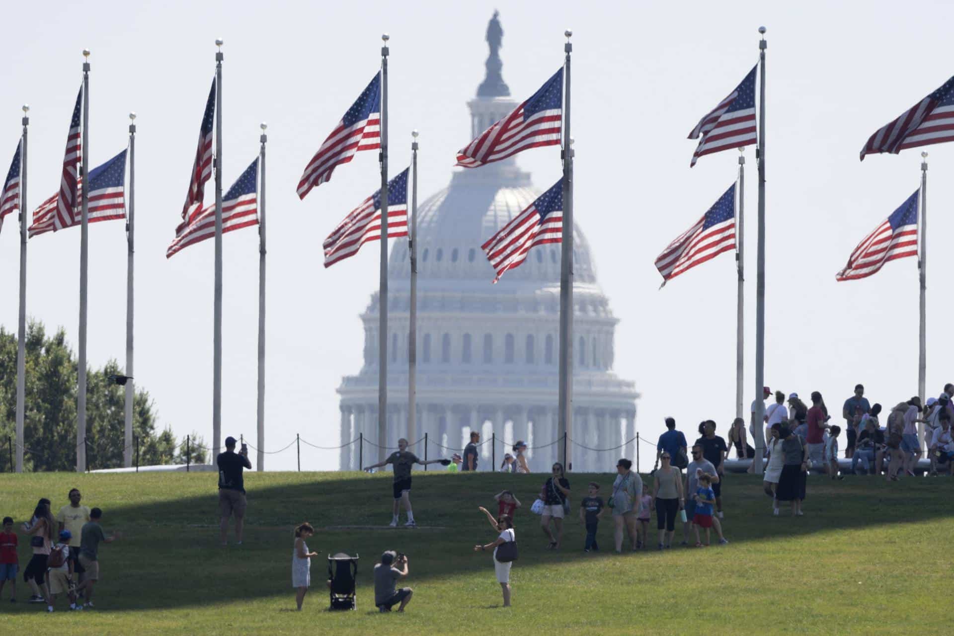 Fotografía de archivo fechada el 21 de junio de 2024 de personas visitando la base del monumento a Washington en el National Mall, con el edificio del Capitolio de los EE. UU. atrás en Washington (EE.UU.). EFE/EPA/MICHAEL REYNOLDS