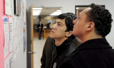 Fotografía de archivo donde aparecen dos personas que buscan trabajo en un tablón de anuncios del centro de desempleo Workforce1 Career Center en Brooklyn, Nueva York, EEUU. EFE/Justin Lane