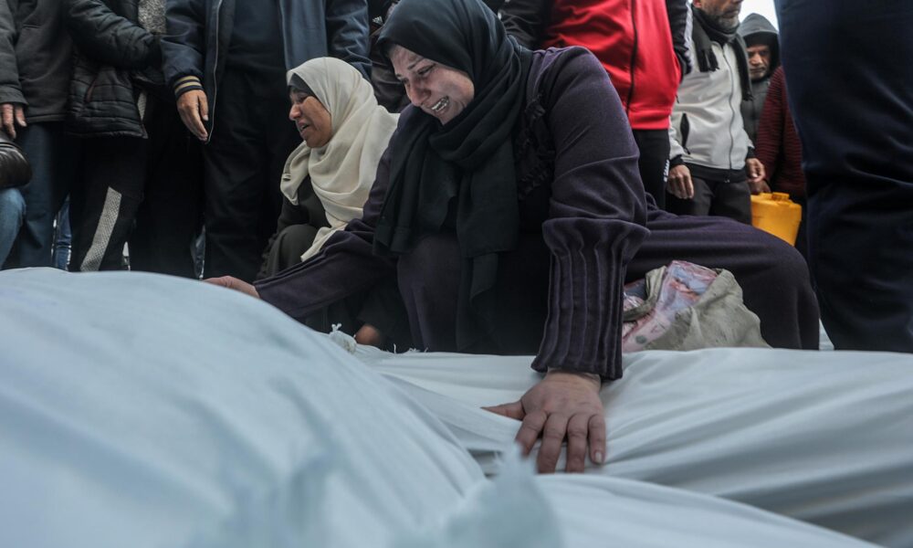 Una mujer palestina llora sobre los cuerpos cubiertos de los miembros de una familia palestina asesinados en un ataque aéreo israelí, en el Hospital de los Mártires de Al Aqsa en la ciudad de Deir Al Balah, en el centro de la Franja de Gaza, 15 de enero de 2025. 
 EFE/EPA/MOHAMMED SABER